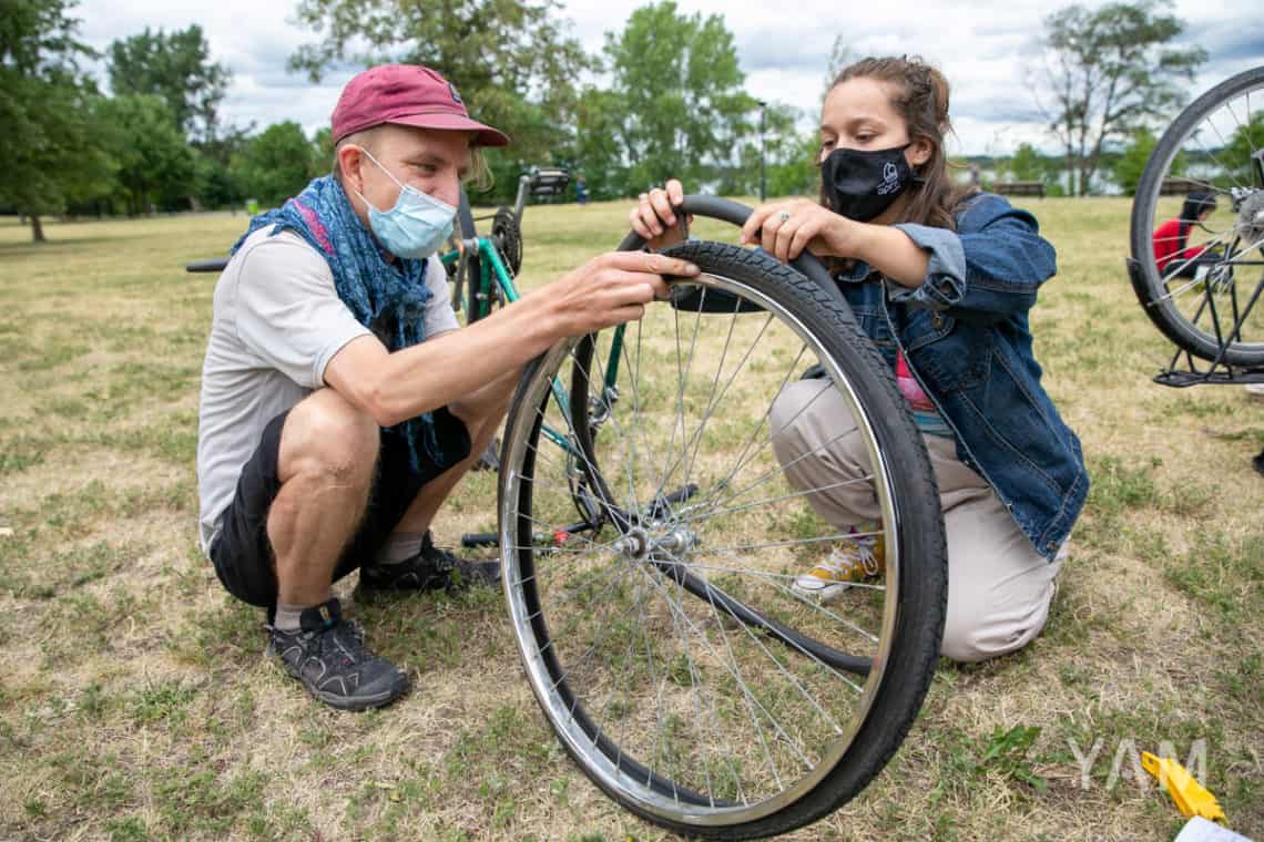 Two volunteers fixing a flat bicycle tire.