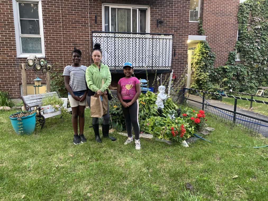 A family poses with their new garden in front of their home.