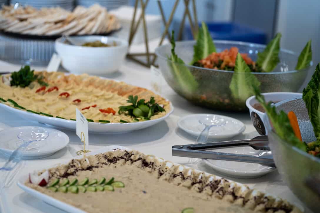 Several platters of food including dips and salads.