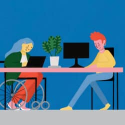 A busy office scene. Two people sit at a desk on their computers and laptop. One of them is in a wheelchair. Either side of them are two office workers who are busy working.