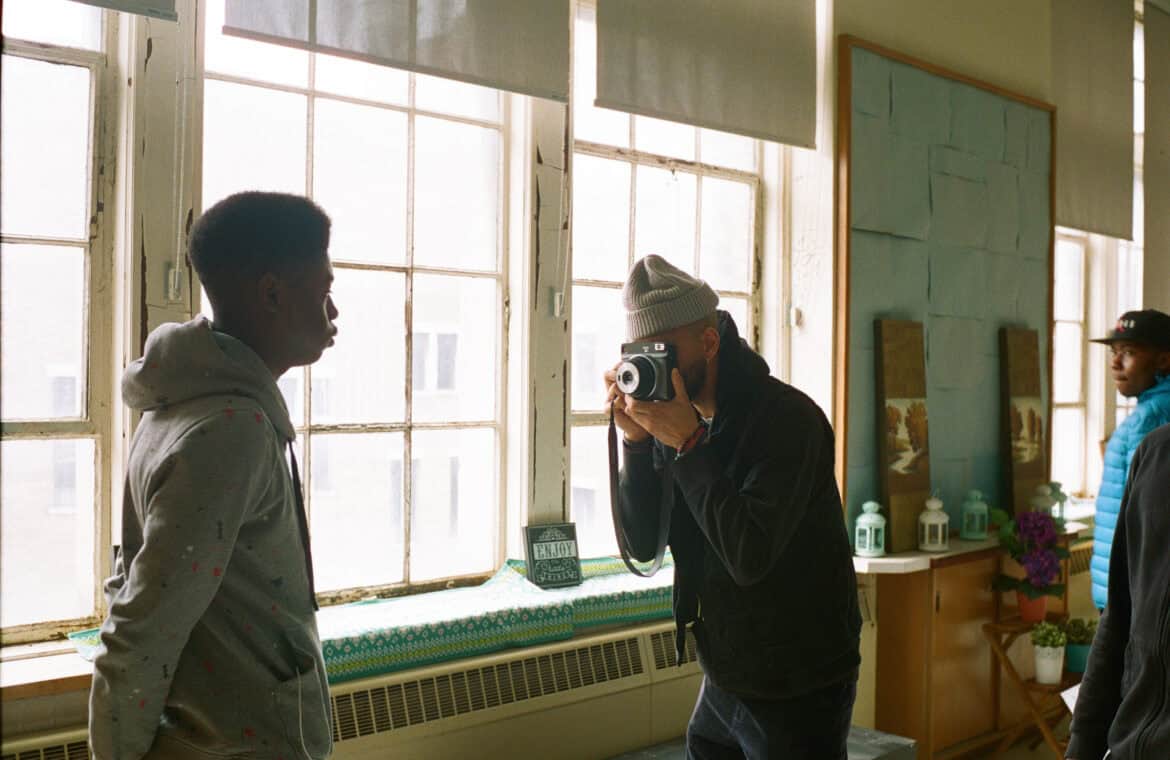 One person posing for another person holding a camera.