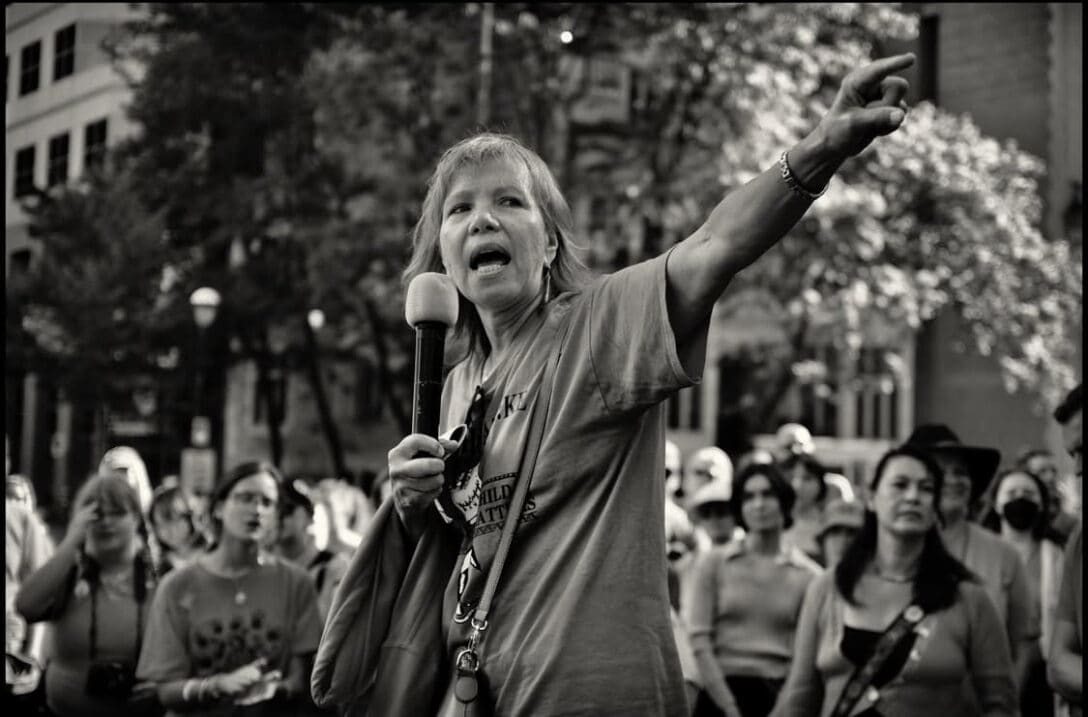 Ellen Gabriel holding a microphone in front of a crowd.