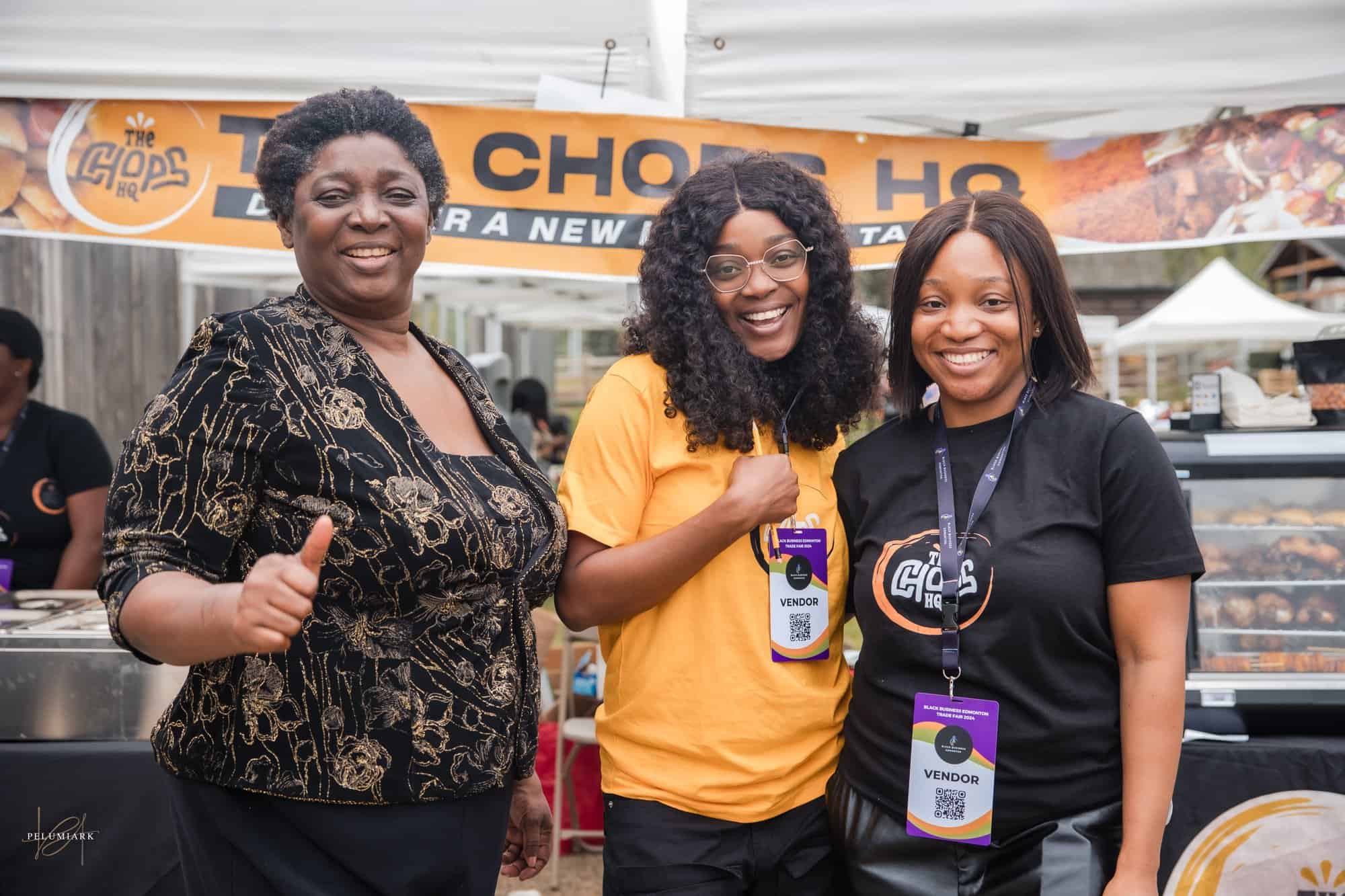 Three women posing with smiles. Two are wearing conference tags that say "vendor."