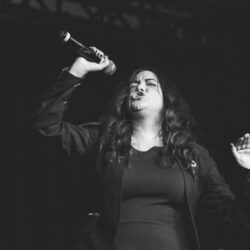 Photo of Lisa J. Smith onstage holding a microphone.