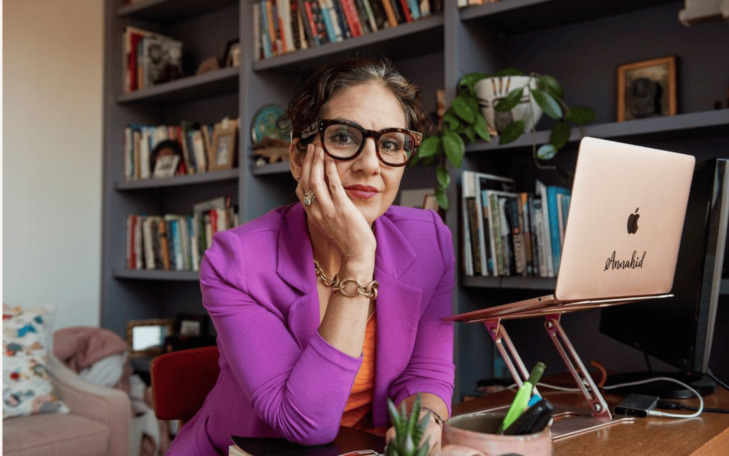 Photo of Annahid Dashtgard sitting at a desk in front of her laptop.
