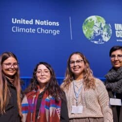 Photo of four women in front of a sign that reads "United Nations Climate Change."